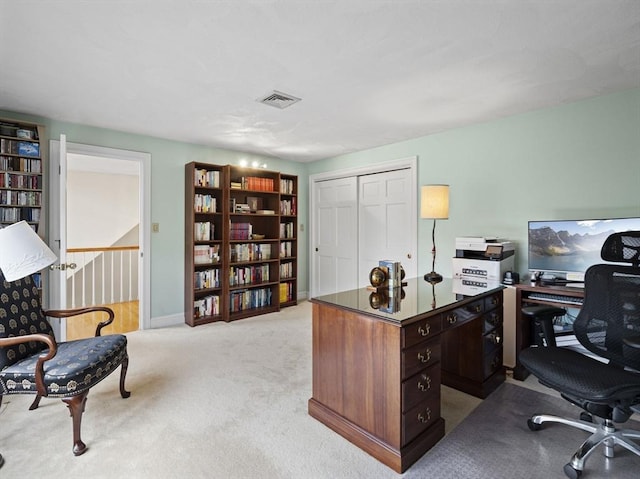 office space featuring baseboards, visible vents, and light colored carpet