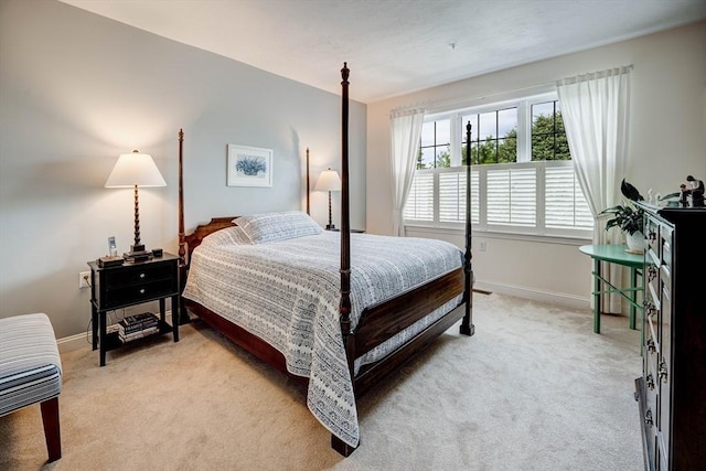 bedroom featuring baseboards and light colored carpet