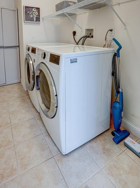 laundry room featuring light tile patterned flooring, washer and clothes dryer, and laundry area