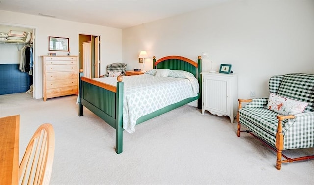 carpeted bedroom with a spacious closet and a closet