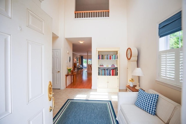 living area featuring a towering ceiling and a wealth of natural light
