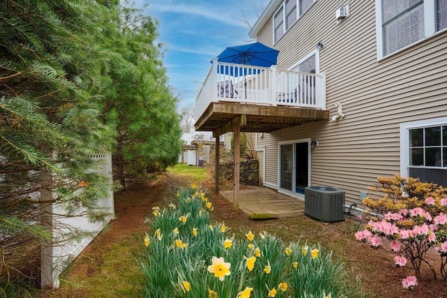 view of yard with central air condition unit and a deck