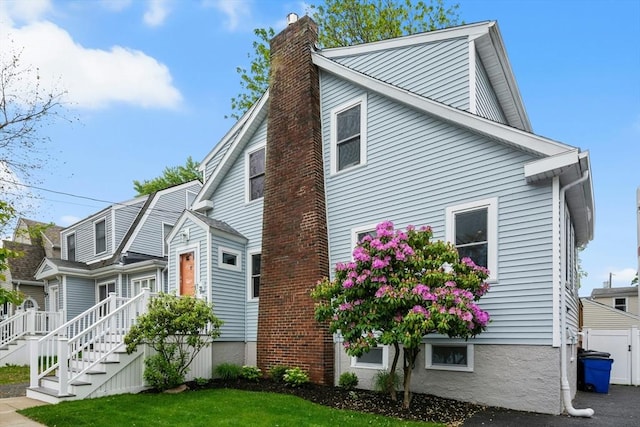 21 Milton Rd, Quincy, MA 02171 - view of side of home featuring a chimney and a lawn