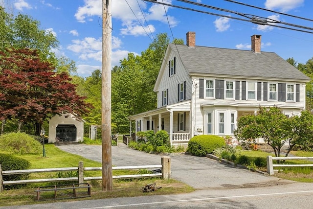 197-199 Main St, Chelmsford, MA 01863 - view of front facade featuring a detached garage, a porch, an outdoor structure, a chimney, and driveway