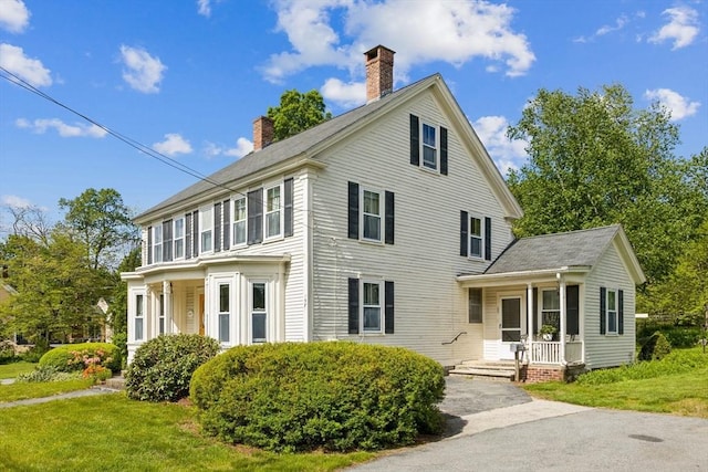 197-199 Main St, Chelmsford, MA 01863 - view of front of house featuring a chimney, a porch, and a front yard