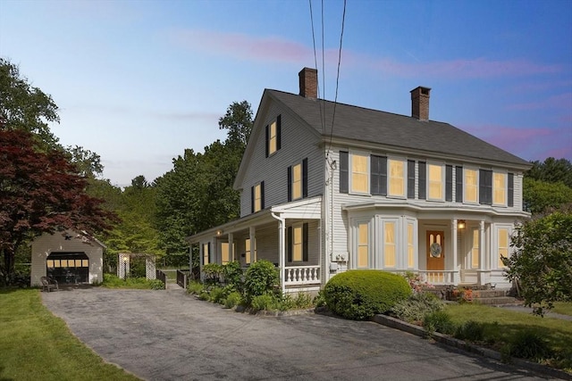 197-199 Main St, Chelmsford, MA 01863 - view of front of house with covered porch, a detached garage, a chimney, and an outdoor structure