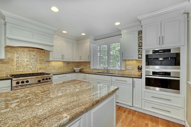 24 Cory Ln, Reading, MA 01867 - kitchen with stainless steel range, a sink, light stone counters, light wood-style flooring, and white cabinets