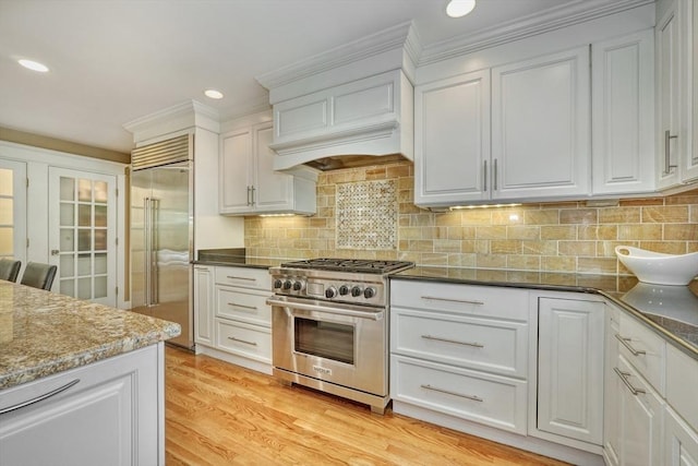 24 Cory Ln, Reading, MA 01867 - kitchen featuring premium appliances, white cabinets, dark stone counters, recessed lighting, and decorative backsplash