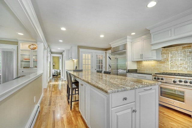 24 Cory Ln, Reading, MA 01867 - kitchen with high quality appliances, white cabinets, a center island, recessed lighting, and backsplash