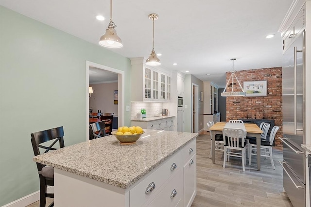 15 Saxon Ln, Shrewsbury, MA 01545 - kitchen with stainless steel built in refrigerator, glass insert cabinets, decorative backsplash, a center island, and white cabinetry