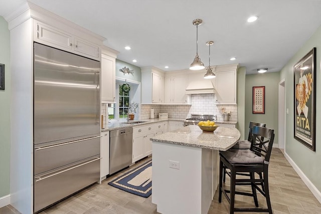 15 Saxon Ln, Shrewsbury, MA 01545 - kitchen featuring appliances with stainless steel finishes, decorative backsplash, a center island, white cabinets, and light stone counters