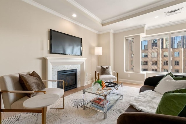 living room with baseboards, visible vents, a tile fireplace, ornamental molding, and wood finished floors