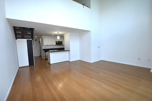 1 Earhart St Unit 320, Cambridge, MA 02141 - unfurnished living room featuring wood finished floors and baseboards