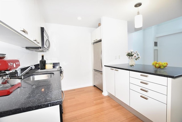 1 Earhart St Unit 320, Cambridge, MA 02141 - kitchen featuring refrigerator, stainless steel microwave, a peninsula, white cabinetry, and recessed lighting