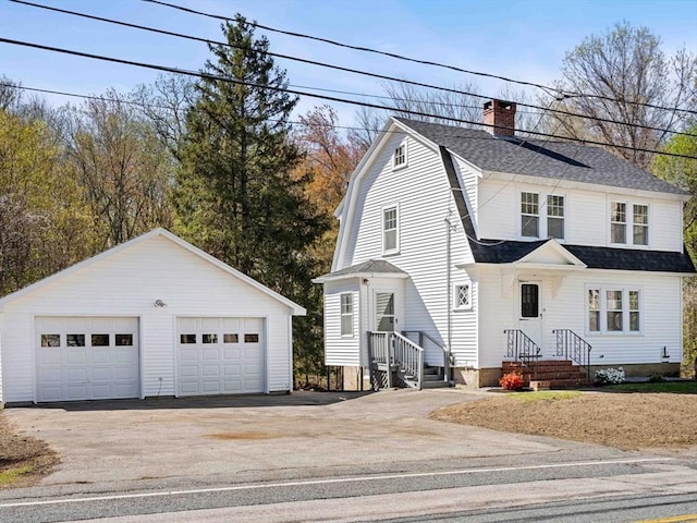 colonial inspired home featuring a chimney, roof with shingles, a garage, an outdoor structure, and a gambrel roof