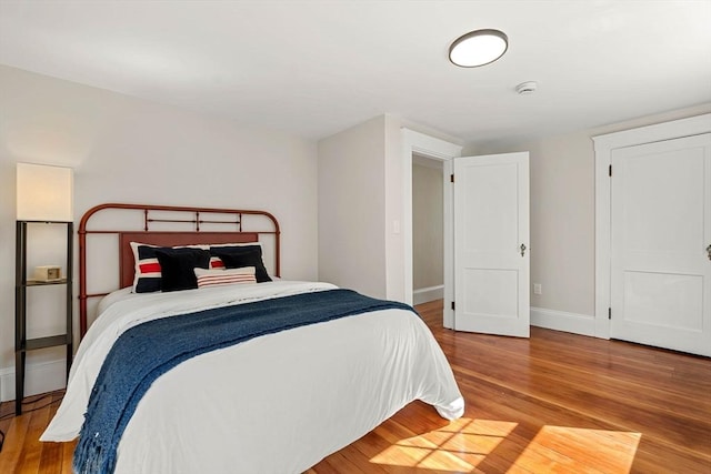 bedroom featuring baseboards and wood finished floors