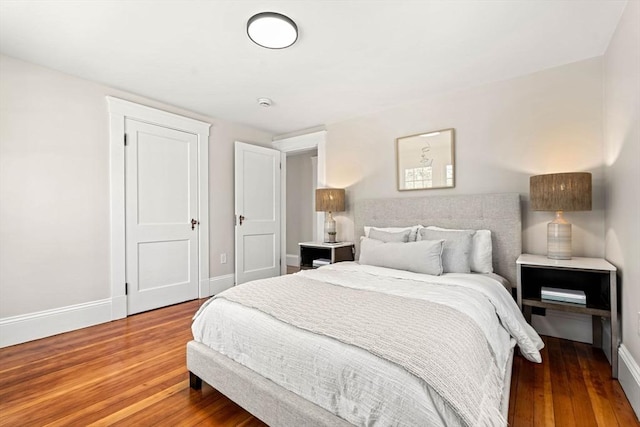 bedroom featuring baseboards and wood finished floors