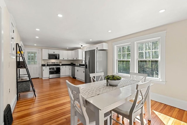 dining space featuring a healthy amount of sunlight, baseboards, recessed lighting, and light wood-type flooring