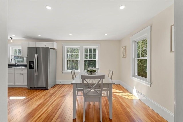 dining area featuring baseboards, plenty of natural light, and light wood-type flooring