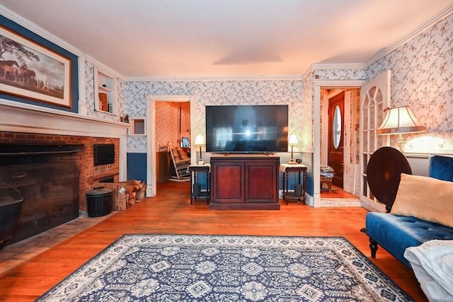 living room featuring a fireplace, wood-type flooring, and ornamental molding