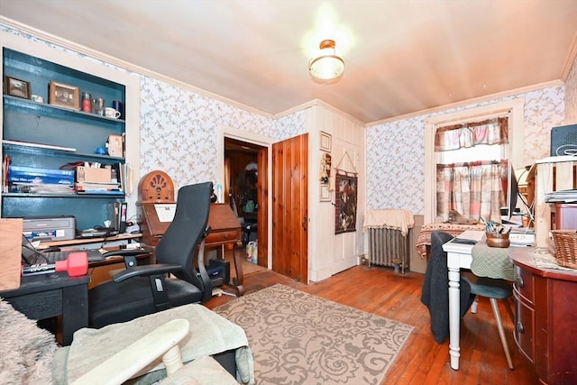 office space with built in shelves, crown molding, radiator heating unit, and hardwood / wood-style floors