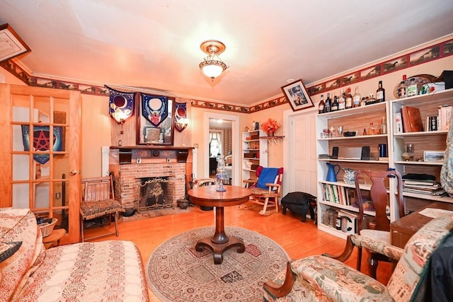 sitting room featuring crown molding, a fireplace, and light hardwood / wood-style floors