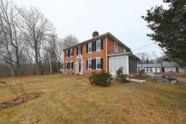 view of side of property featuring a yard and a sunroom