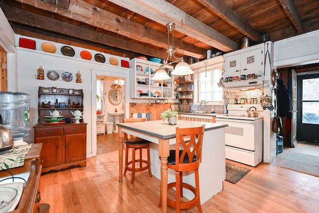 kitchen featuring white cabinetry, a center island, white range with electric cooktop, decorative light fixtures, and a kitchen bar