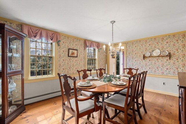 dining room with light wood finished floors, a wainscoted wall, wallpapered walls, and a chandelier