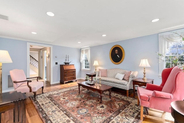 living room featuring stairway, recessed lighting, wood finished floors, and ornamental molding