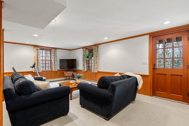 carpeted living room featuring recessed lighting, a wainscoted wall, ornamental molding, and wood walls