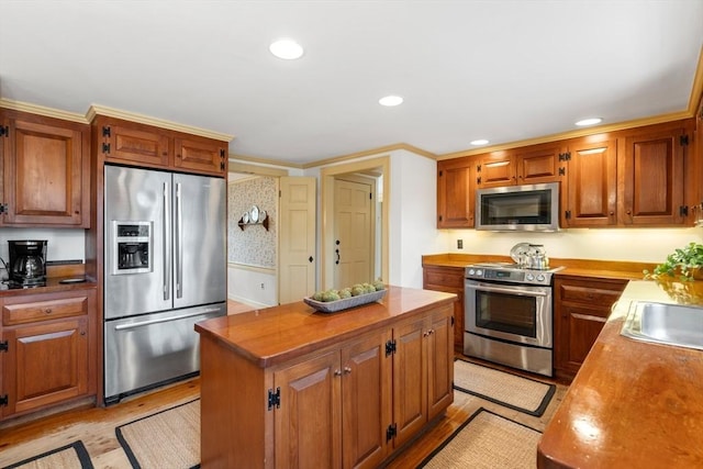 kitchen featuring stainless steel appliances, a kitchen island, light wood-style flooring, and brown cabinetry