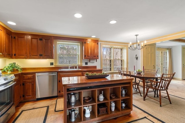 kitchen with recessed lighting, appliances with stainless steel finishes, light wood-style flooring, a notable chandelier, and a sink