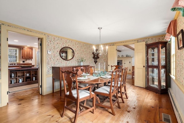 dining area featuring visible vents, wallpapered walls, wainscoting, light wood finished floors, and a baseboard radiator