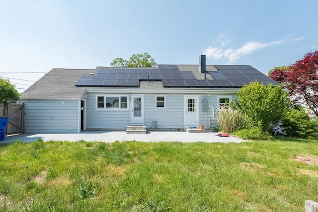 70 Puritan Rd, Bourne, MA 02532 - rear view of property with entry steps, a patio area, roof mounted solar panels, and roof with shingles
