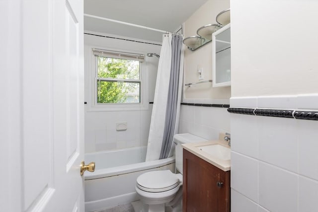 70 Puritan Rd, Bourne, MA 02532 - bathroom featuring vanity, toilet, shower / bath combination with curtain, tile walls, and a wainscoted wall