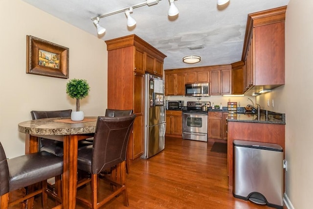 kitchen featuring dark wood-type flooring and stainless steel appliances