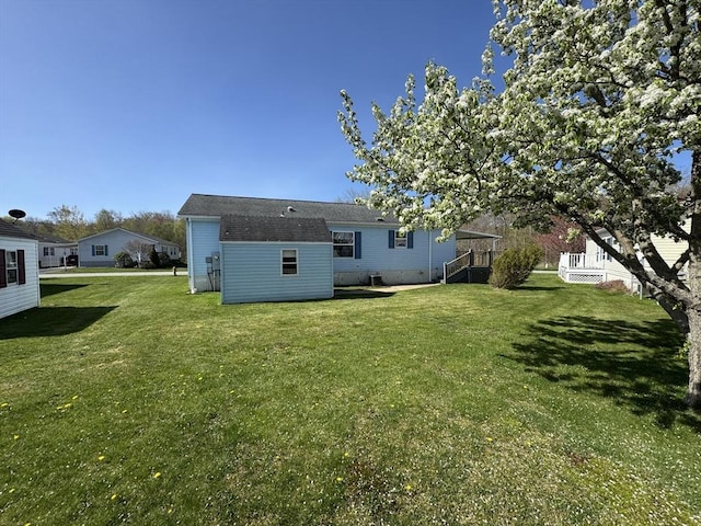 back of property featuring a lawn and a deck