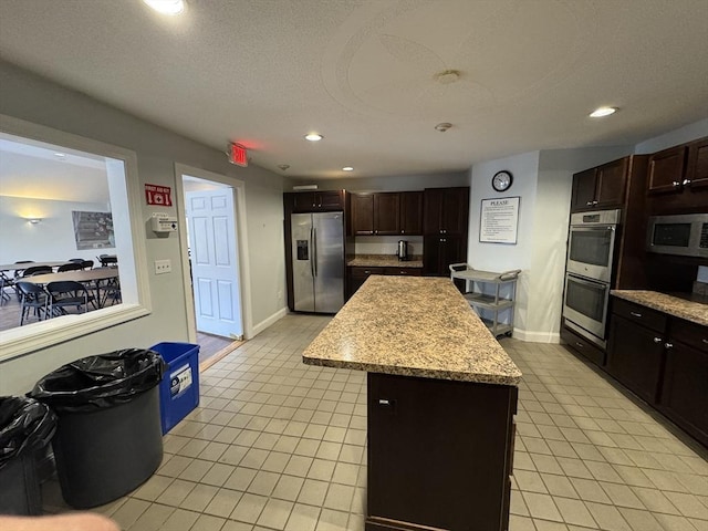 kitchen with light tile patterned floors, a center island, stainless steel appliances, and recessed lighting