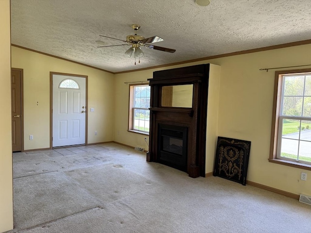 unfurnished living room with carpet flooring, a ceiling fan, and a wealth of natural light