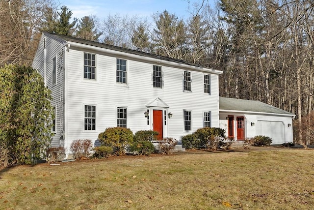 colonial inspired home with a garage and a front lawn