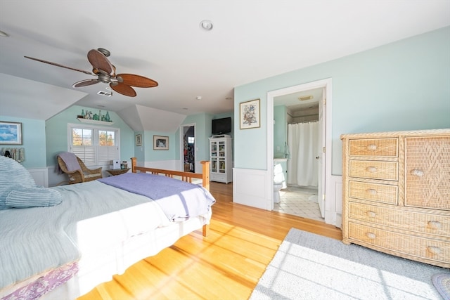 bedroom with hardwood / wood-style floors, ensuite bathroom, ceiling fan, and lofted ceiling