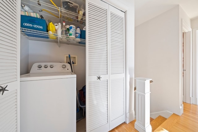 washroom with hardwood / wood-style flooring and washer / clothes dryer