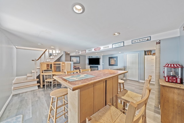 kitchen featuring a kitchen bar and light hardwood / wood-style flooring