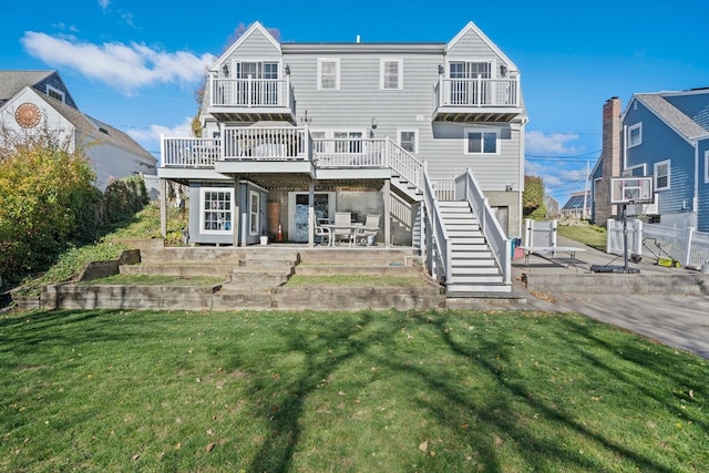 rear view of house featuring a patio, a lawn, and a wooden deck