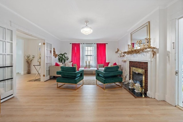 sitting room featuring crown molding, a fireplace, and light hardwood / wood-style floors