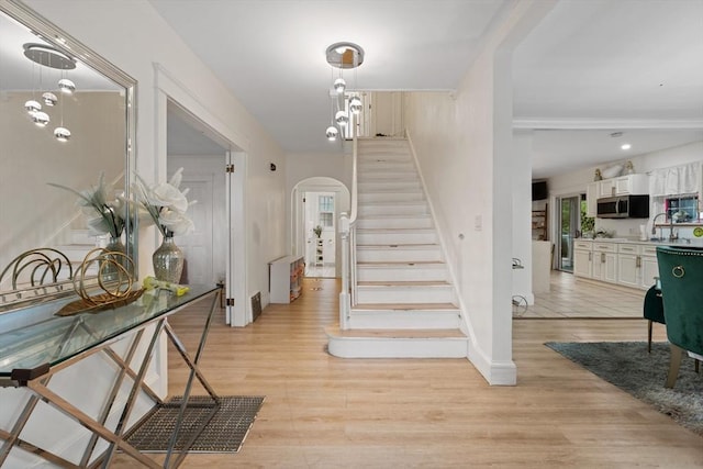 staircase with wood-type flooring and sink