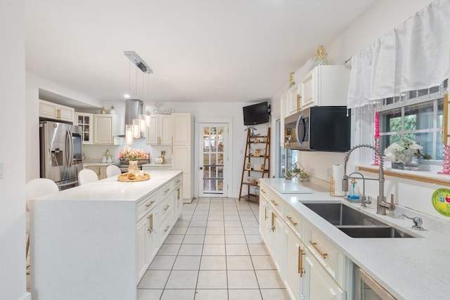 kitchen with sink, wall chimney exhaust hood, hanging light fixtures, plenty of natural light, and appliances with stainless steel finishes