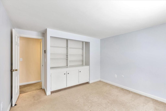 unfurnished bedroom featuring light colored carpet and a closet