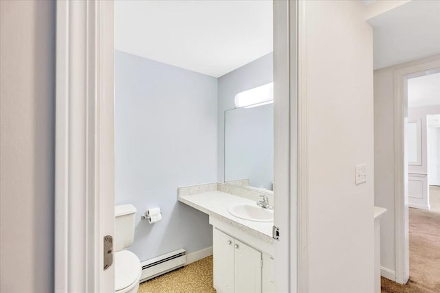 bathroom with toilet, vanity, and a baseboard heating unit